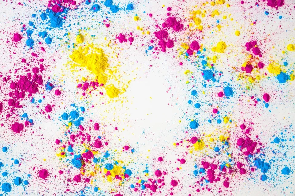Cyan-, Magenta- und Gelbpigmentpulver, verstreut auf weißem Hintergrund